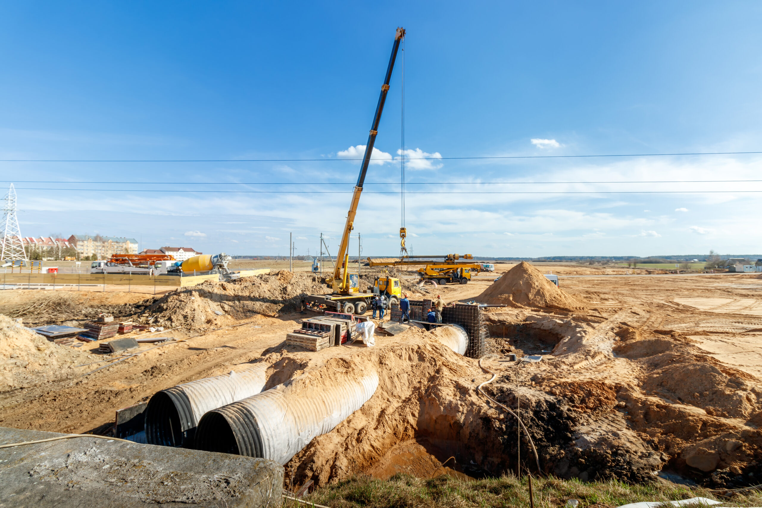 Connecting a trench drain to a concrete manhole structure at construction site. Concrete pile in formwork frame for construct stormwater and underground utilities, pump stations, sewers pipes.